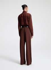 woman wearing brown silk top and matching pants
