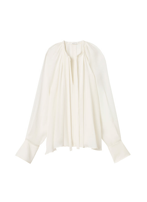 flatlay of cream v neck silk blouse