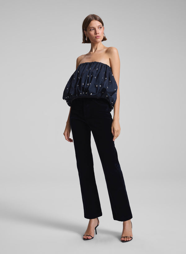 woman wearing navy blue embellished strapless top and navy blue velvet pants