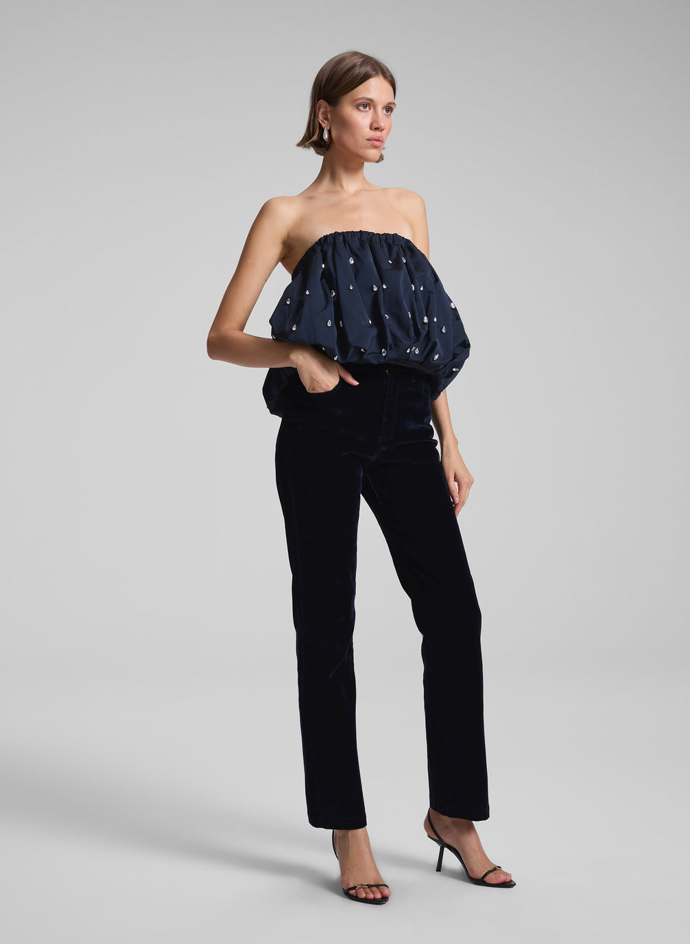 woman wearing navy blue embellished strapless top and navy blue velvet pants