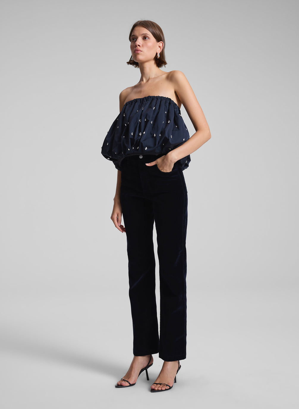 woman wearing navy blue embellished strapless top and navy blue velvet pants