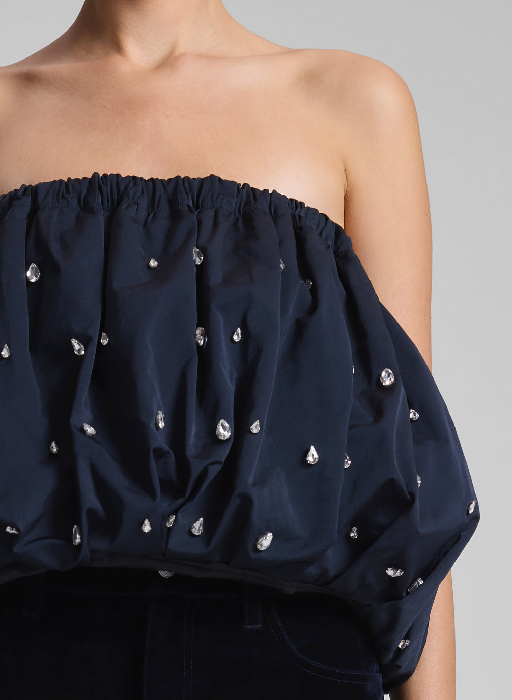 woman wearing navy blue embellished strapless top and navy blue velvet pants