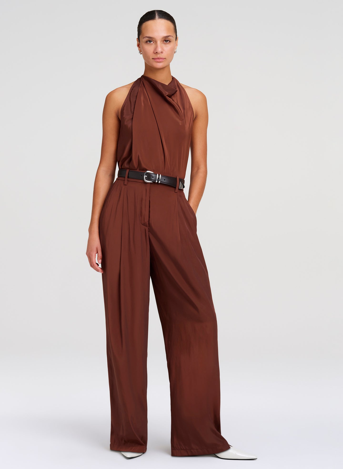 Woman wearing a brown top with a belt on a white background