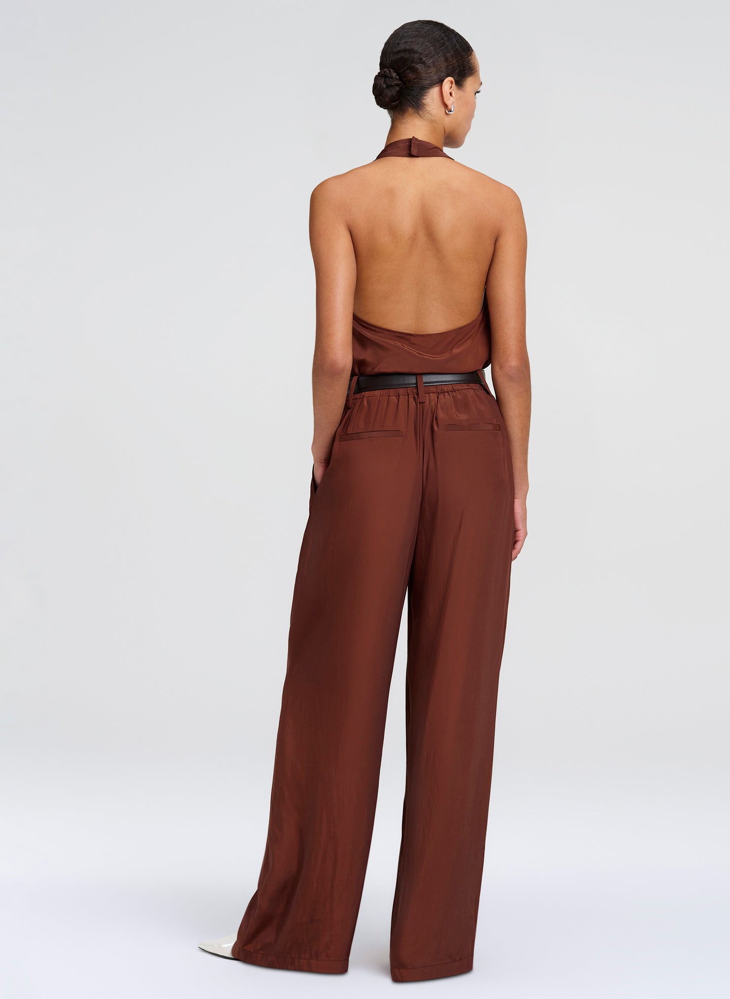 Woman wearing a brown top and pants on a white background