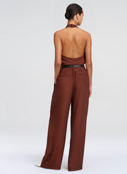 Woman wearing a brown top and pants on a white background