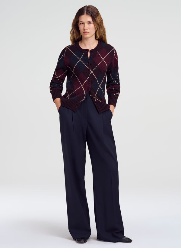 woman in argyle cardigan and navy blue trousers