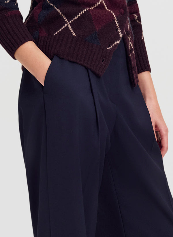 woman in argyle cardigan and navy blue trousers