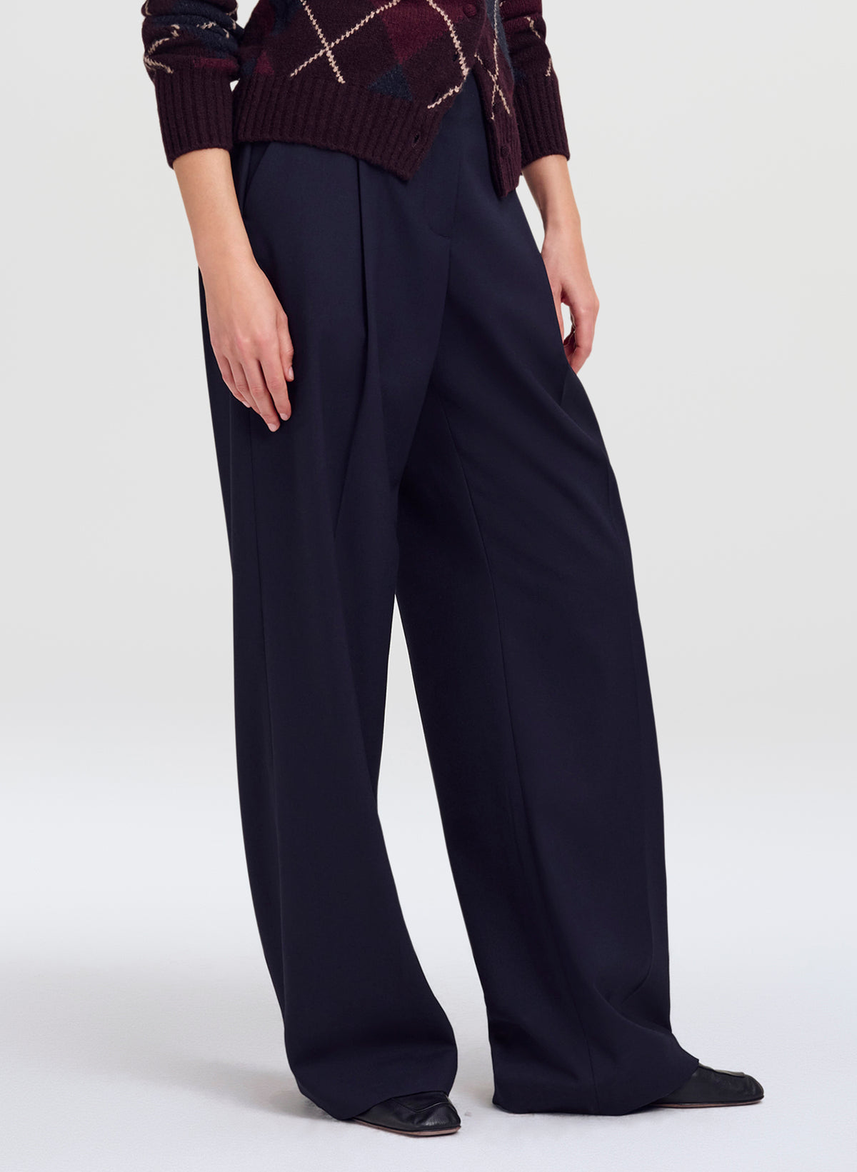woman in argyle cardigan and navy blue trousers