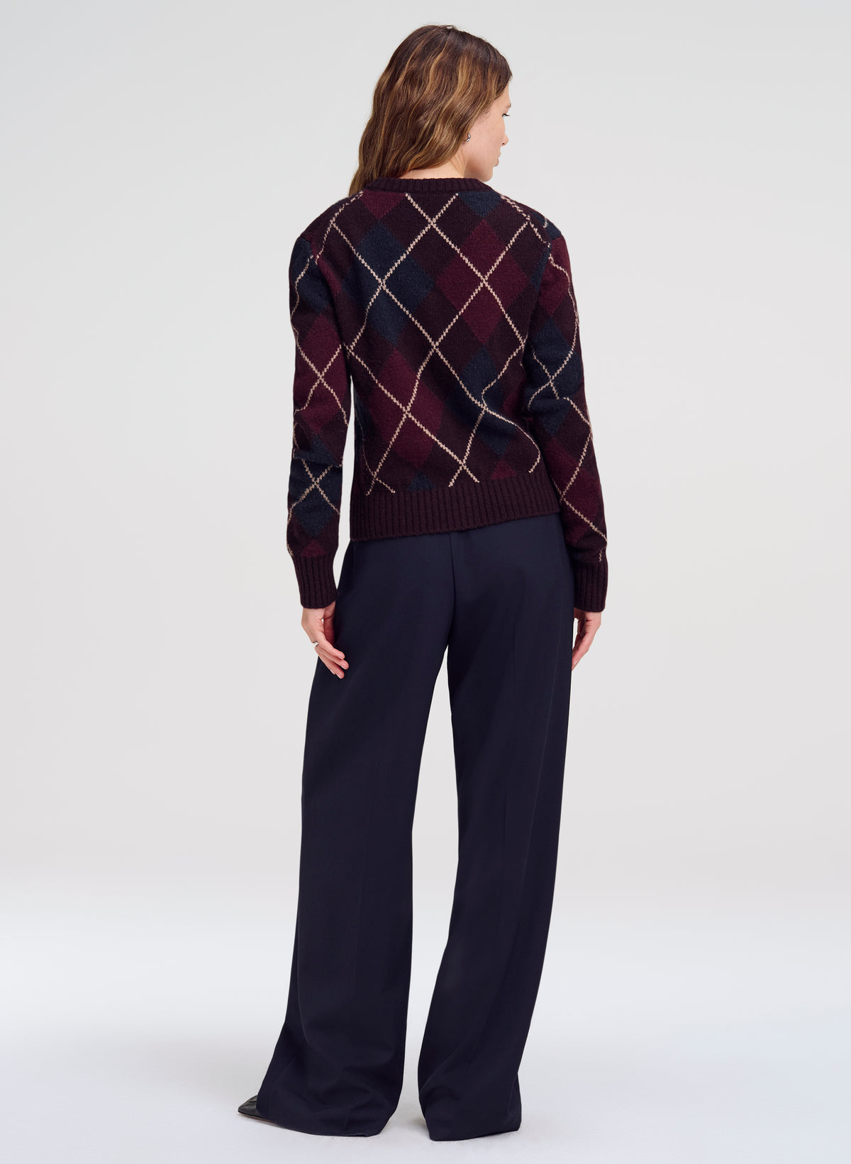 woman in argyle cardigan and navy blue trousers