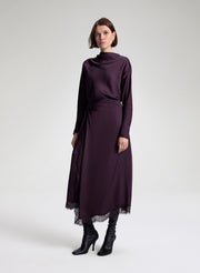 woman wearing purple long sleeve top and matching purple midi skirt