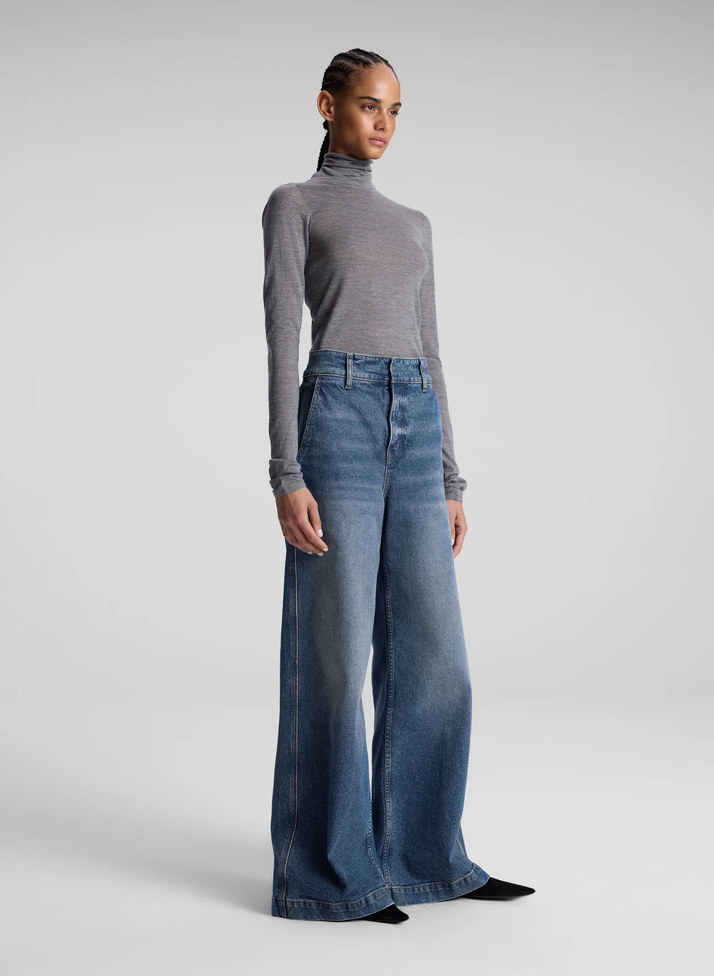 woman wearing grey turtleneck and wide leg medium blue jeans