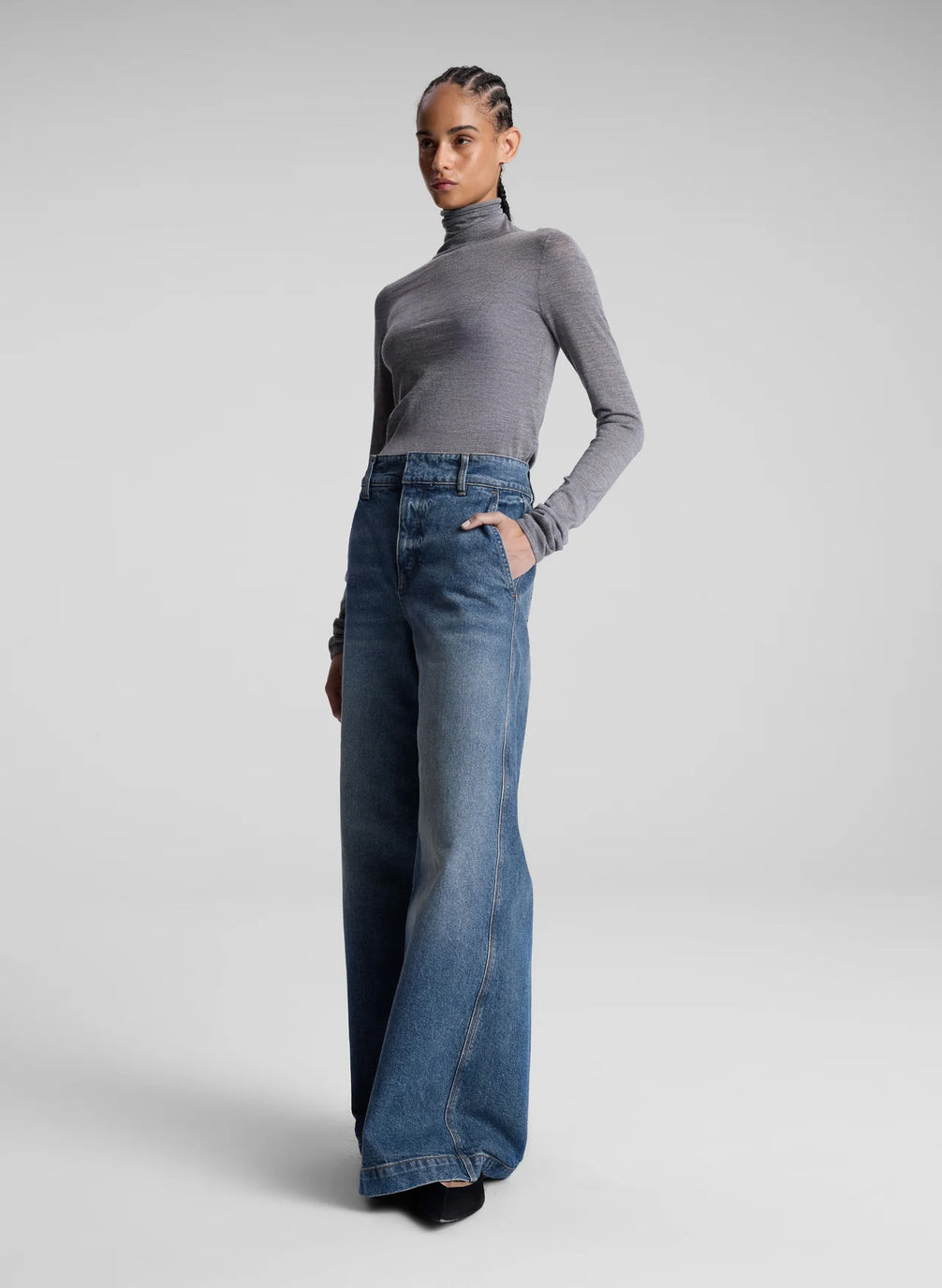 woman wearing grey turtleneck and wide leg medium blue jeans