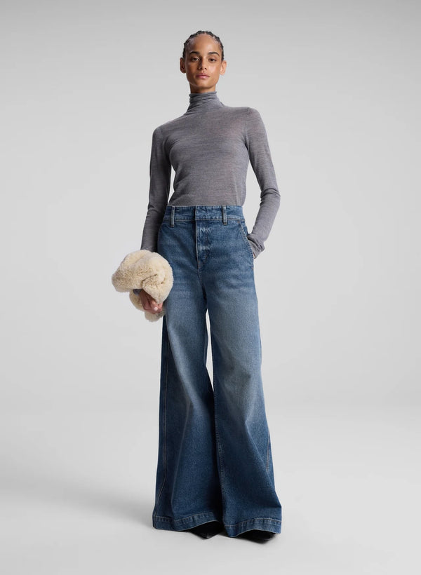 woman wearing grey turtleneck and wide leg medium blue jeans