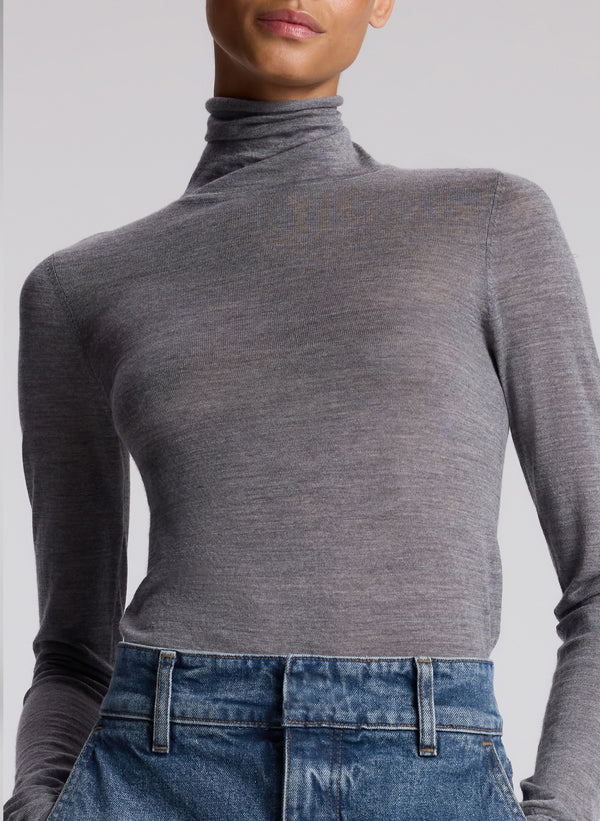 woman wearing grey turtleneck and wide leg jeans
