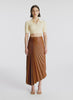 video view of woman wearing cream cropped collared knit shirt and brown pleated vegan leather skirt