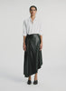 video view of woman wearing white button down top and black pleated vegan leather skirt