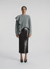 video view of woman wearing grey sweater with ruffle and brown sequin midi skirt