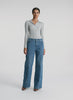360 view of woman in silver long sleeve top and medium blue wash jeans