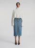 video view of woman wearing white turtleneck sweater and denim midi skirt