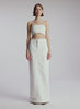 video view of woman wearing off white cropped strapless top with white maxi skirt