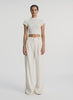 video view of woman wearing ivory short sleeve open weave top and beige wide leg pants