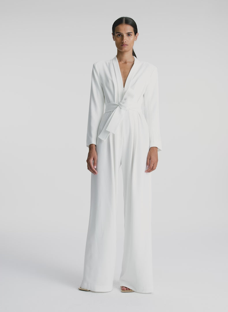 video view of woman wearing white long sleeve jumpsuit