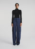 360 view of woman wearing black knit long sleeve top and blue satin cargo pants