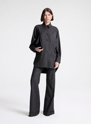 Person wearing a black shirt and pants on a white background