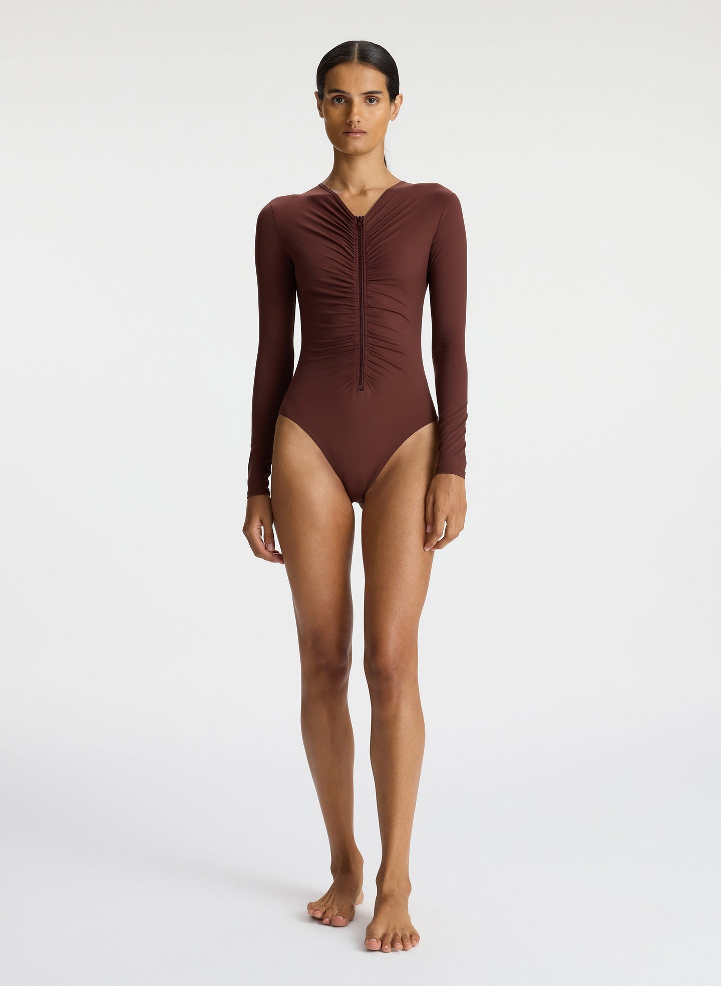 front view of woman wearing brown long sleeve zip front swimsuit