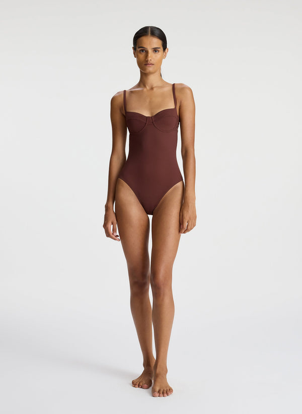 front view of woman wearing brown one piece swimsuit