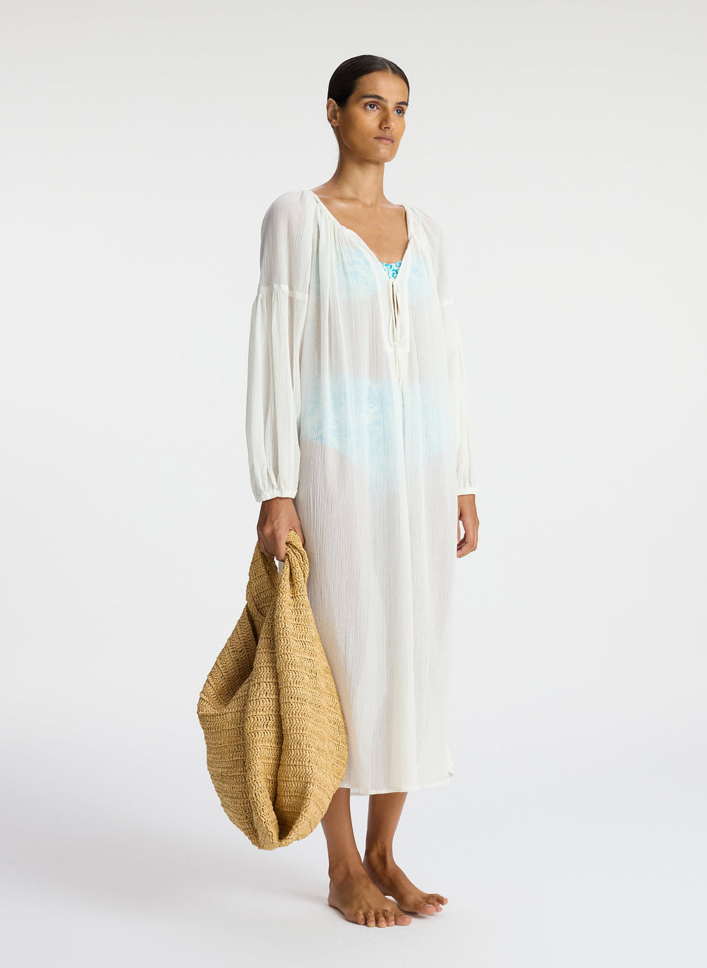 side view of woman wearing white sheer swim cover up dress