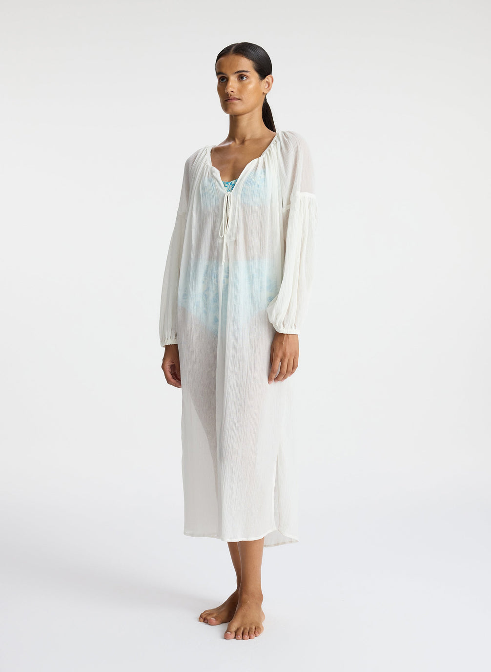 side view of woman wearing white sheer swim cover up dress