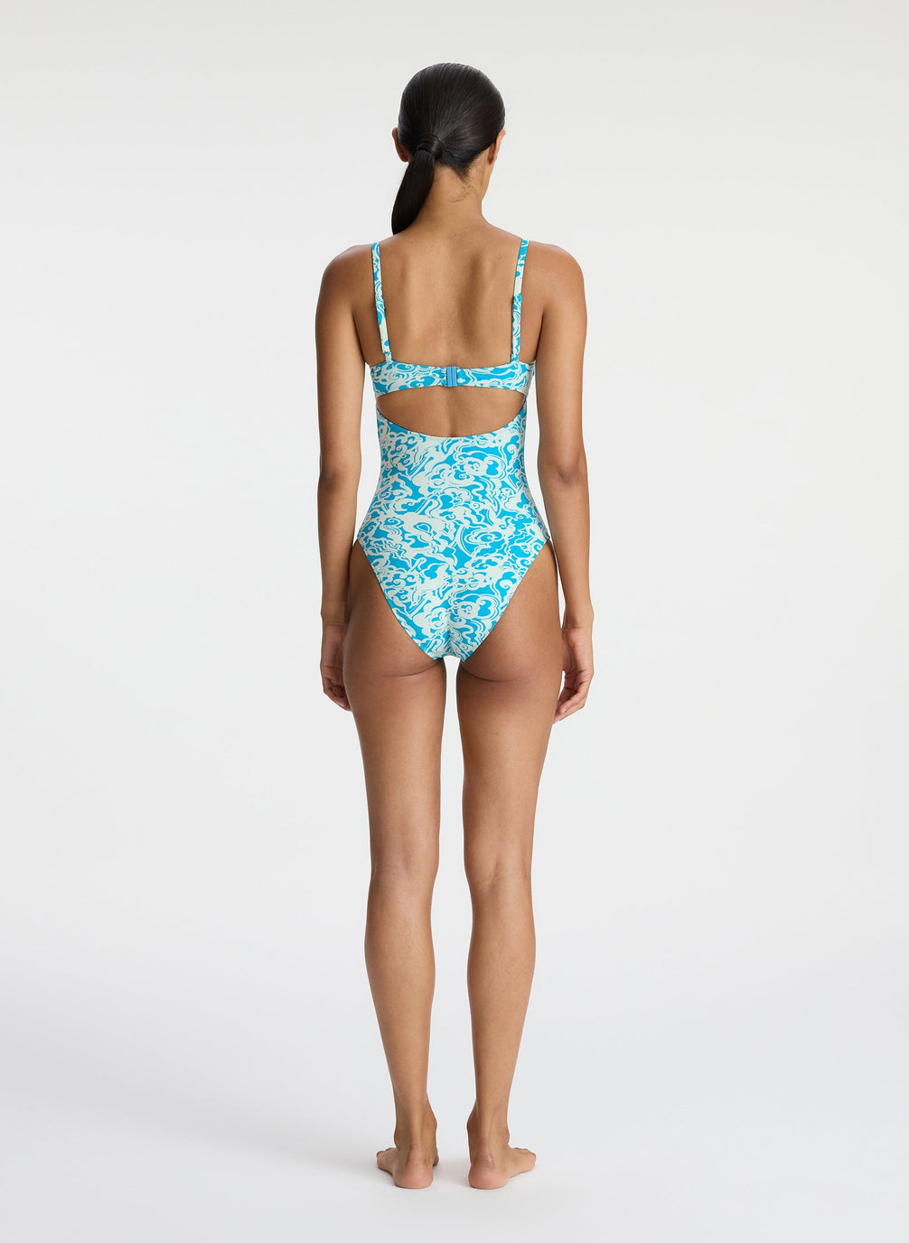 back view of woman wearing aqua print one piece swimsuit