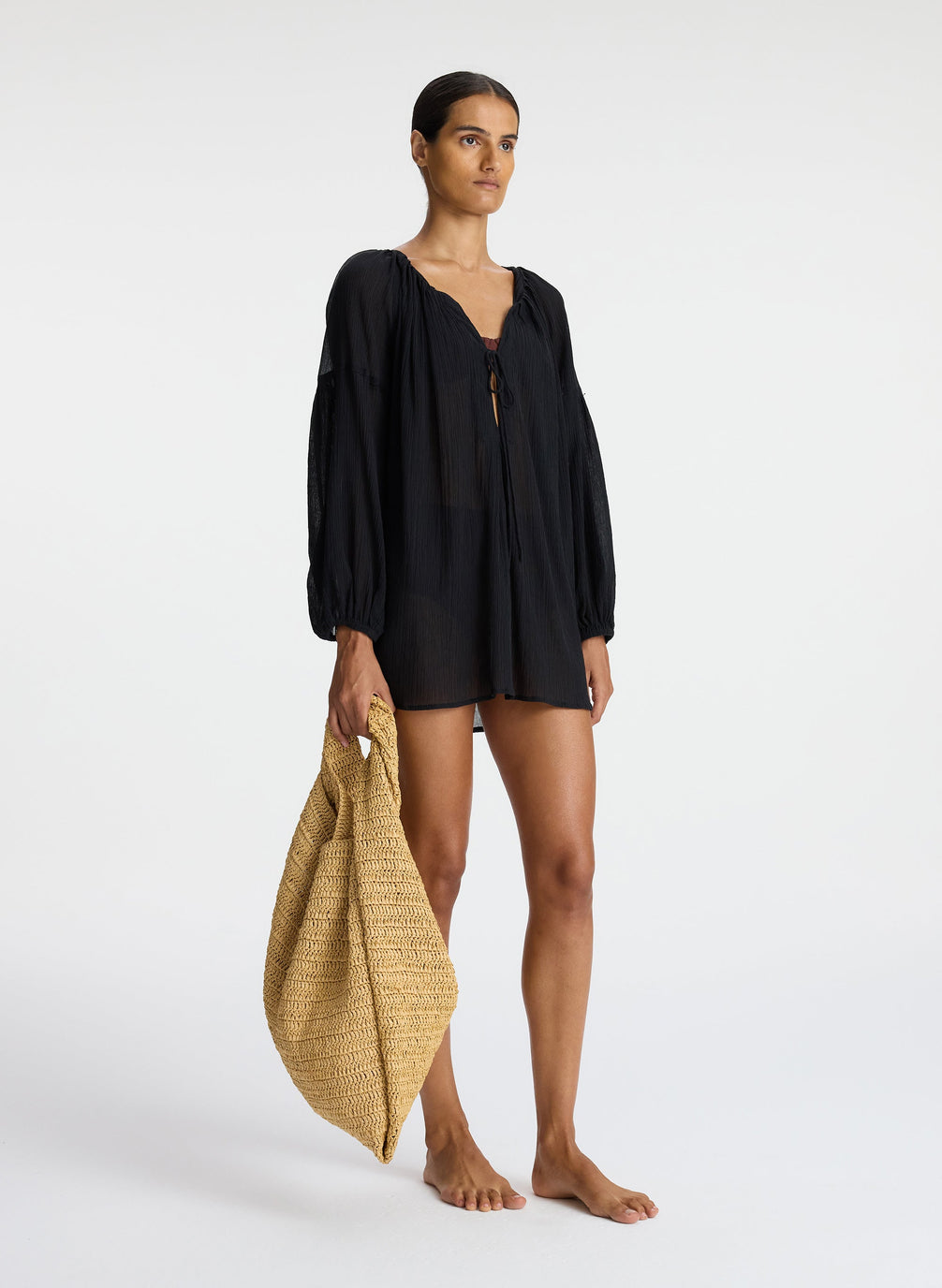 side view of woman wearing short black swim cover up