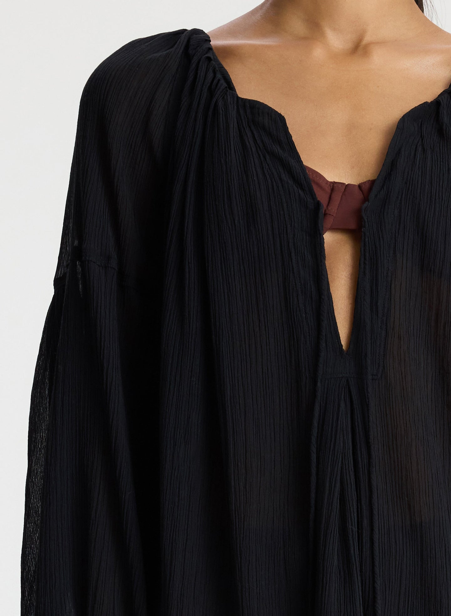 detail of woman wearing short black swim cover up