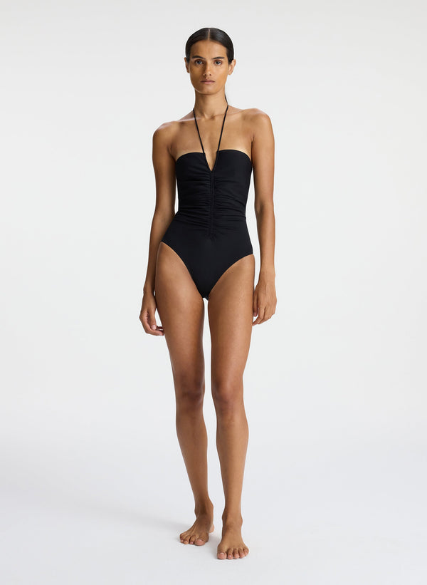 front view of woman wearing black halter one piece swimsuit