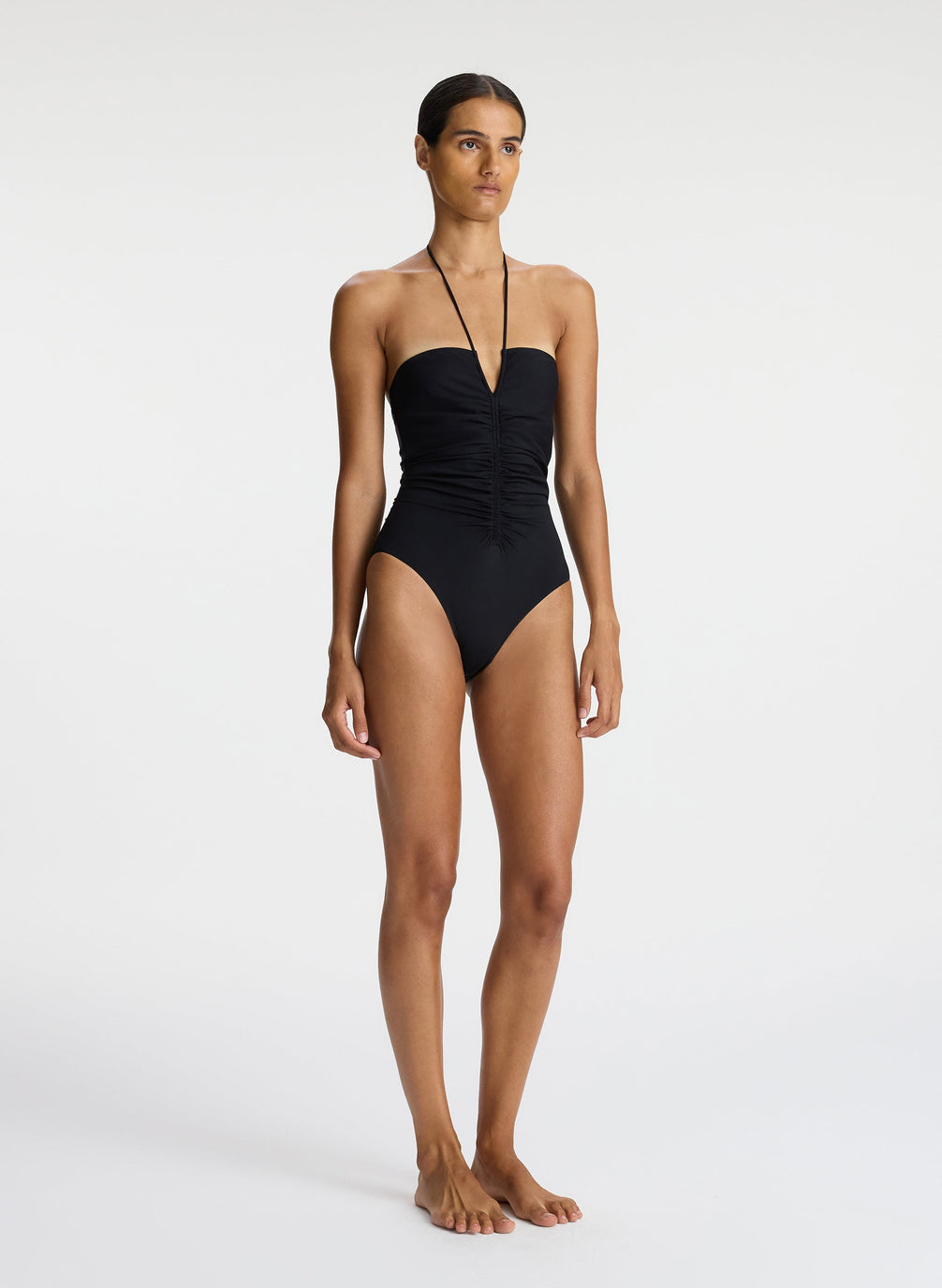 side view of woman wearing black halter one piece swimsuit