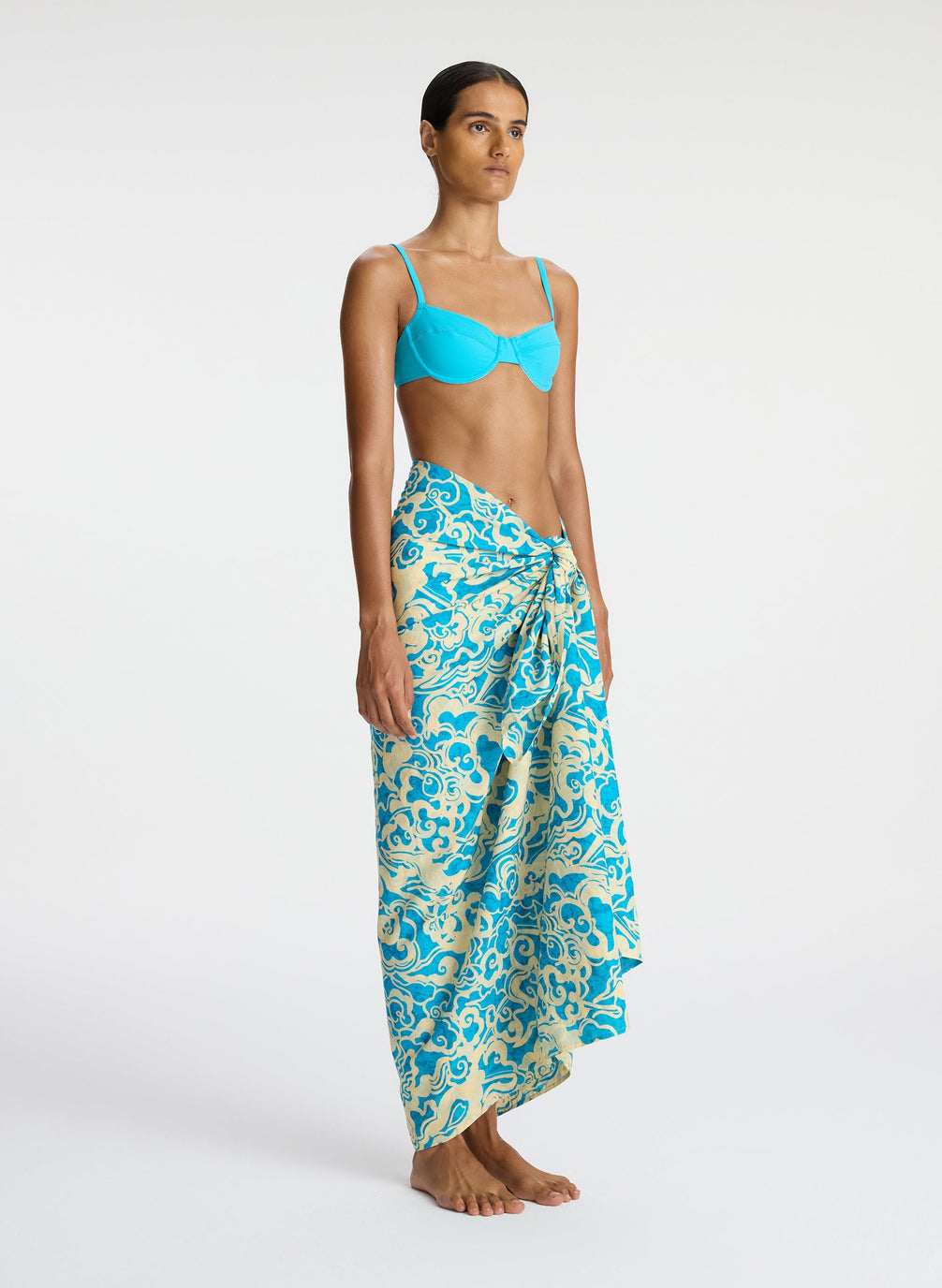 side view of woman wearing aqua bikini and aqua print sarong
