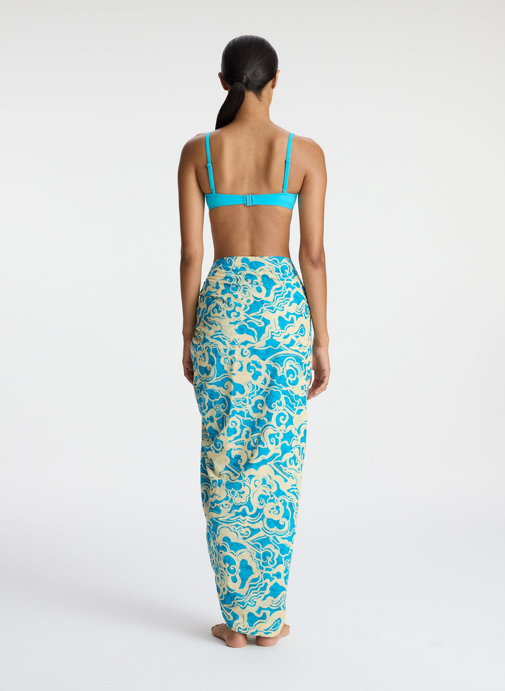 back view of woman wearing aqua bikini and aqua print sarong